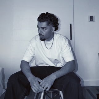 Black and white seated portrait of Moe Vision
